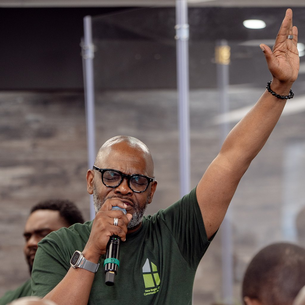 Bishop Robert Francis speaking into a microphone with one hand raised